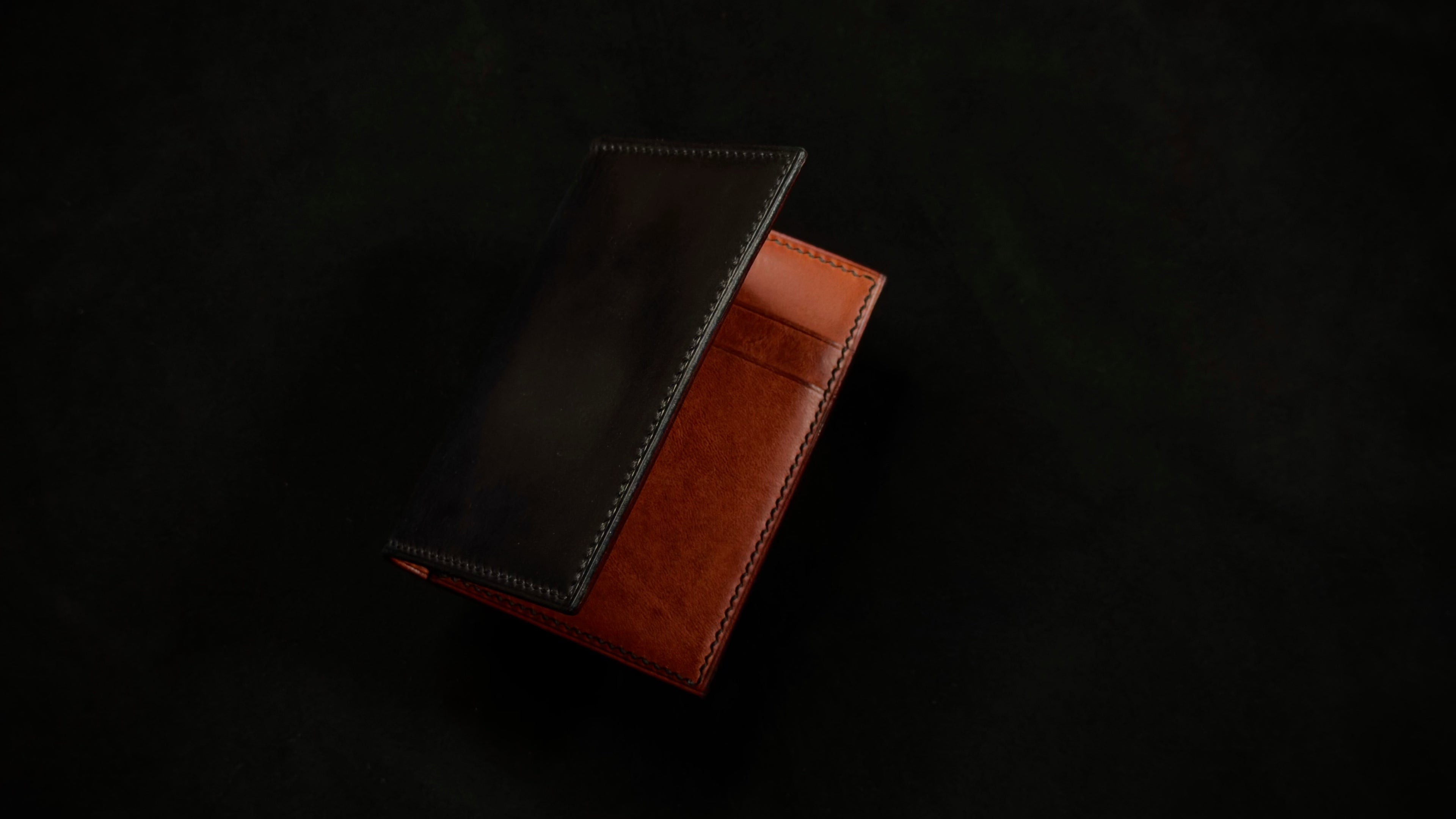 Brown leather card wallet on a black background