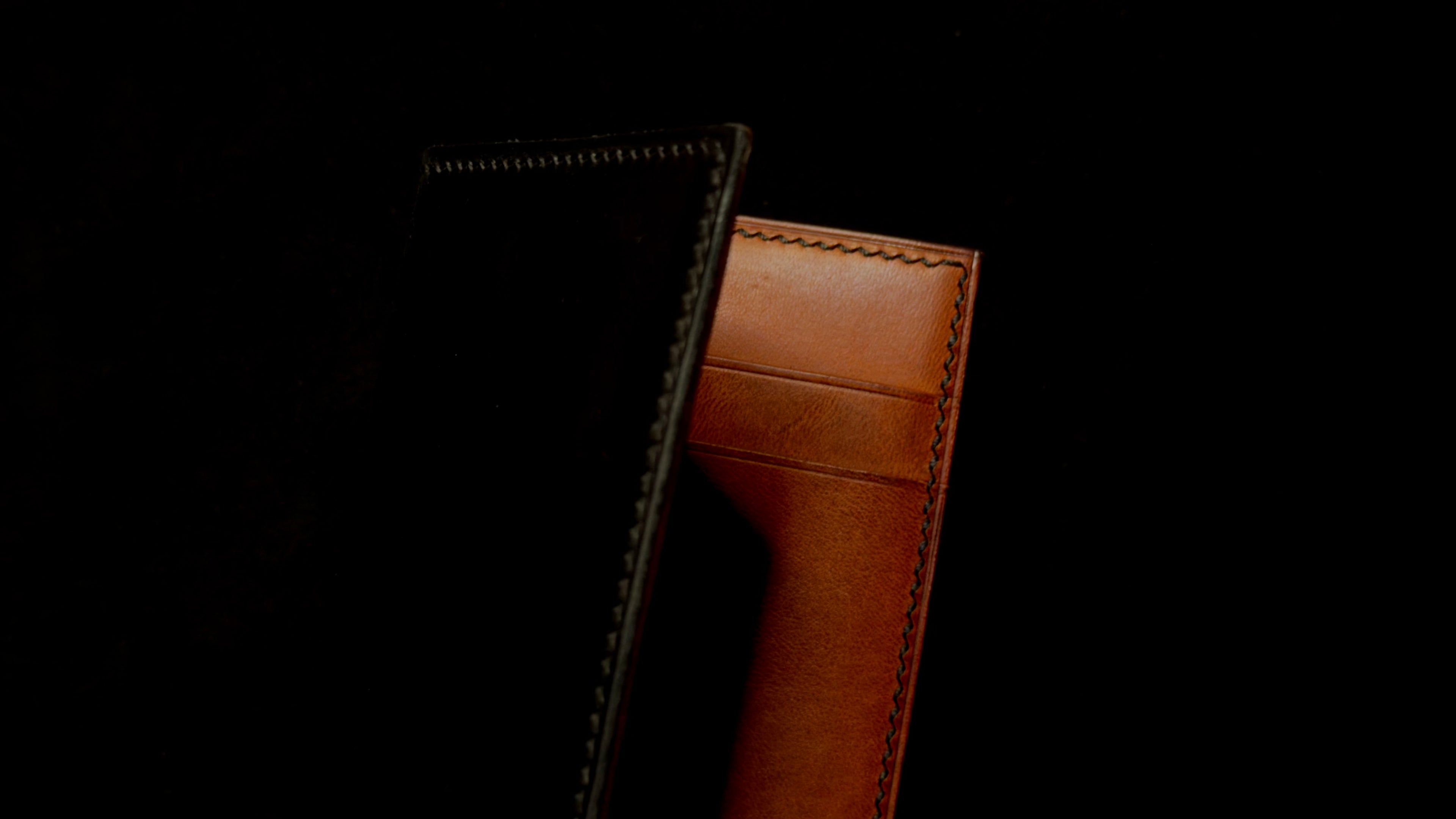 Brown leather card wallet on a black background